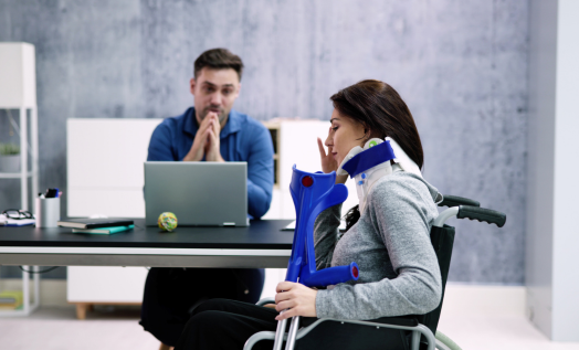 a person in a wheelchair sitting in front of a laptop